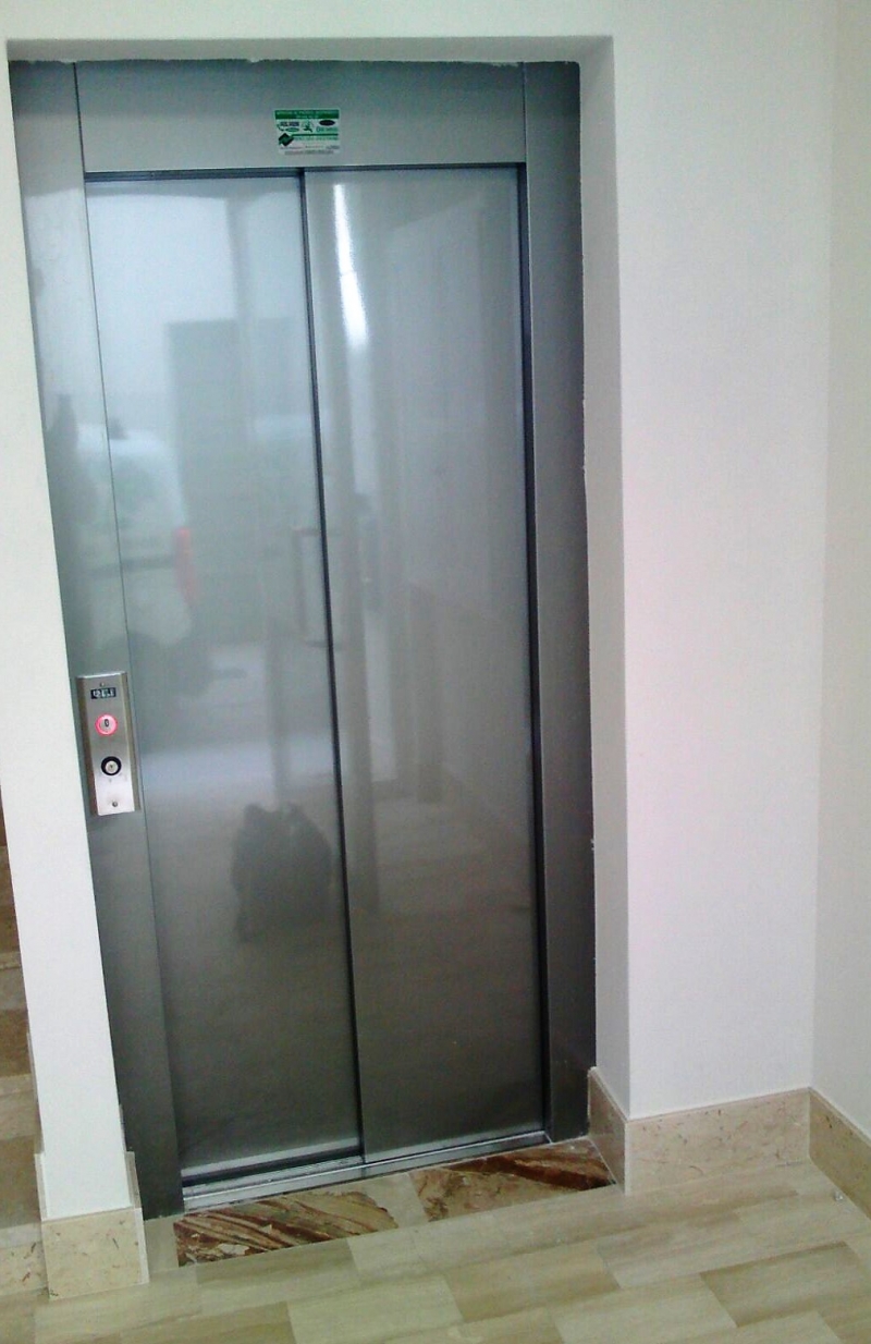 particolare esterno dell'ascensore costruito con vano in muratura; le porte sono telescopiche a due ante per un massimo comfort nel servizio.