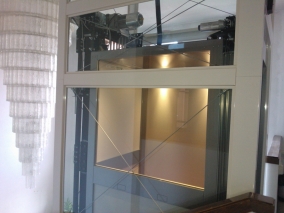 Installazione di ascensore panoramico in vetro per interni.